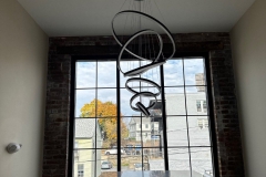 All Phase Electric LLC | Multi-ring LED pendant hung over a stone counter in a converted mill space | Southern NH